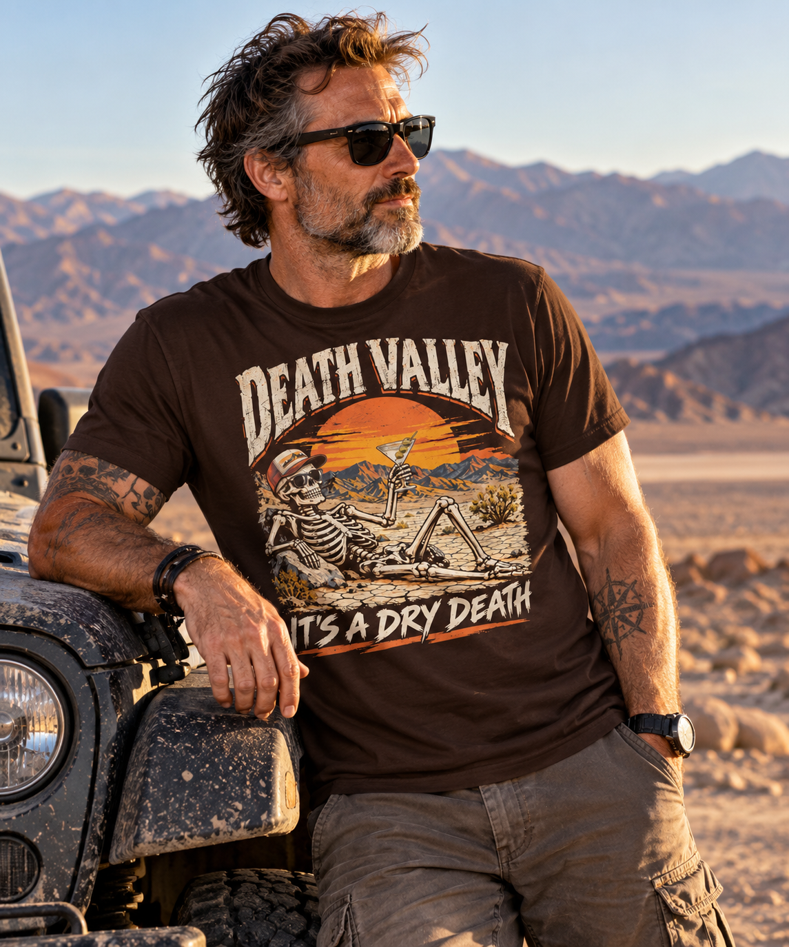 A man wearing a death valley skeleton t-shirt, brown graphic tee, skull in sunglasses illustration, desert sunset badge design, martini cocktail graphic, vintage travel style print, cracked desert landscape art, dry humor streetwear shirt, unisex crew neck shirt