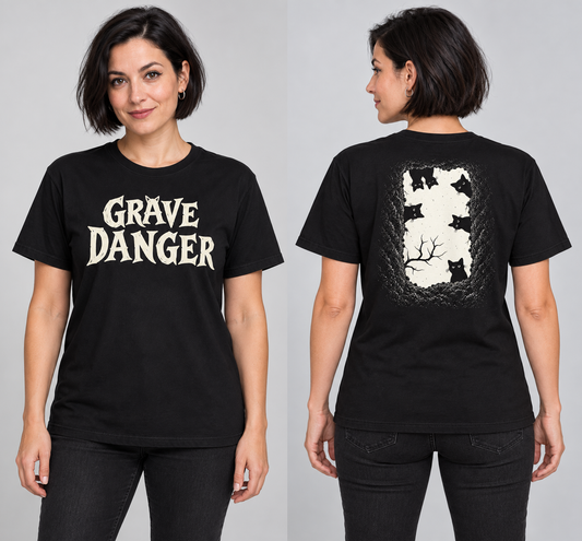grave danger t-shirt, black graphic tee, gothic wordmark front design, black cat grave illustration back, two-sided halloween shirt, spooky cemetery graphic print, cream ink gothic lettering, torn earth night sky design, eerie cat peeking art, unisex crew neck shirt
