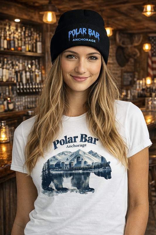 Polar Bar Anchorage cuffed beanie with icy blue embroidered logo worn by female model inside bar with Polar Bar t-shirt warm Edison bulb lighting black beanie