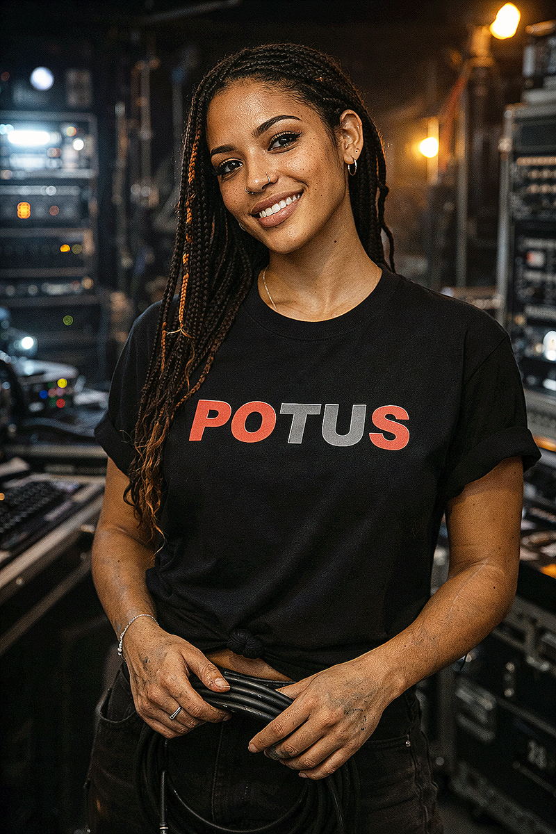 POTUS political satire typography tee worn by female model with braids in backstage equipment room black t-shirt