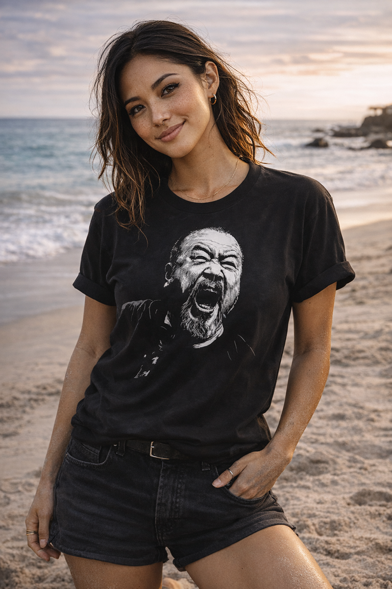 Scream of Defiance bold protest portrait graphic tee worn by female model on California beach at golden hour sunset black t-shirt