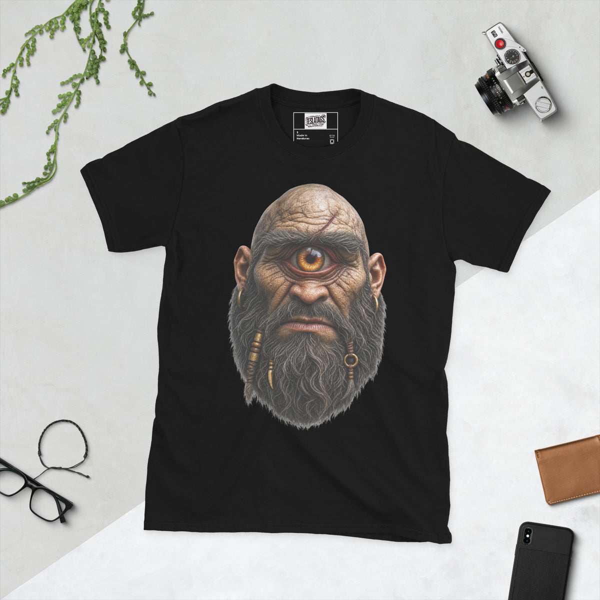 cyclops t-shirt, black and white graphic tee, one eyed giant illustration, braided beard design, gold hoop earring graphic, scarred bald head design, mythical monster tee, halloween horror shirt, gothic streetwear design, unisex crew neck shirt