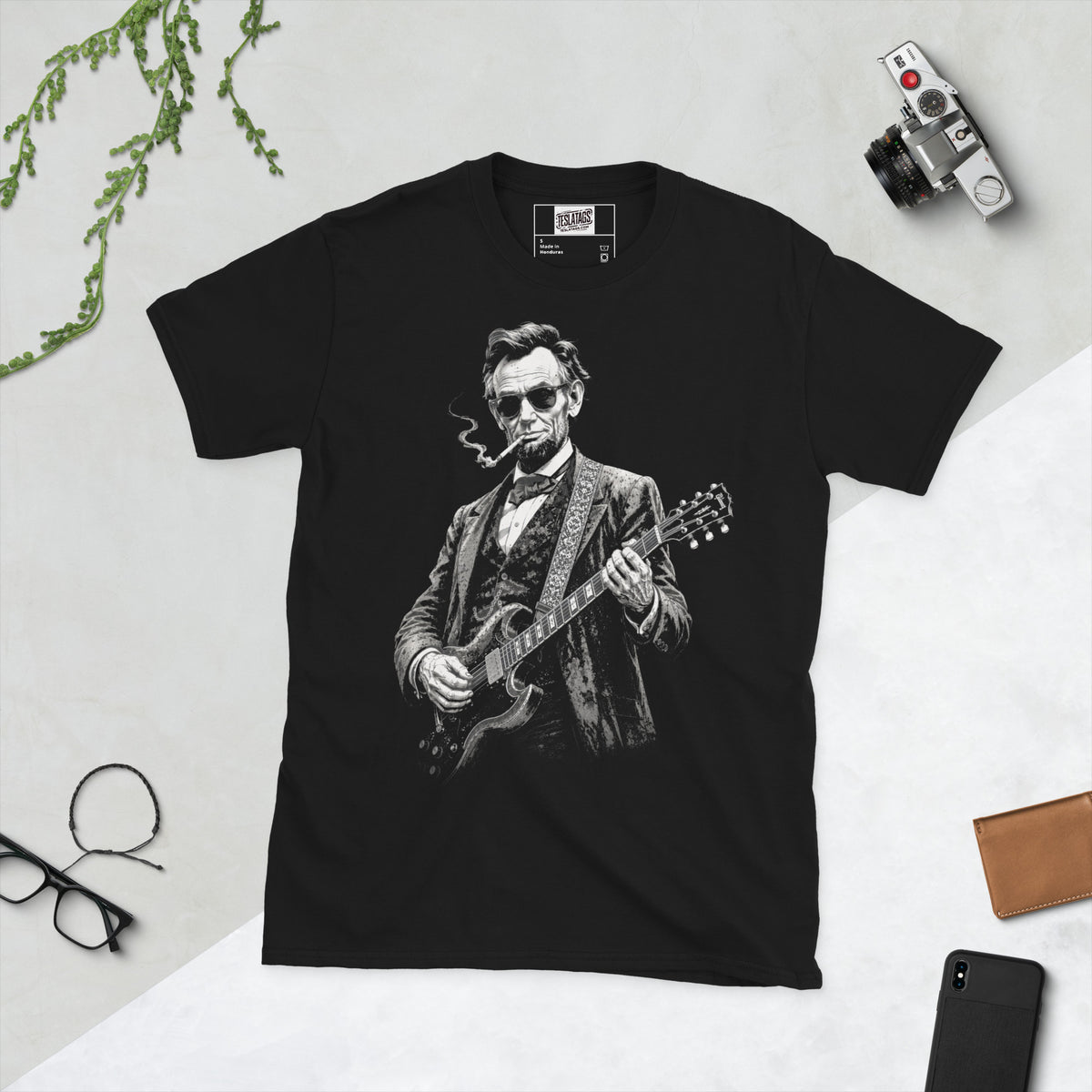 abraham lincoln t-shirt, black graphic tee, president playing electric guitar, rock star portrait design, sunglasses guitar illustration, americana rock graphic, vintage president style shirt, guitar solo print design, patriotic rock streetwear, unisex crew neck shirt