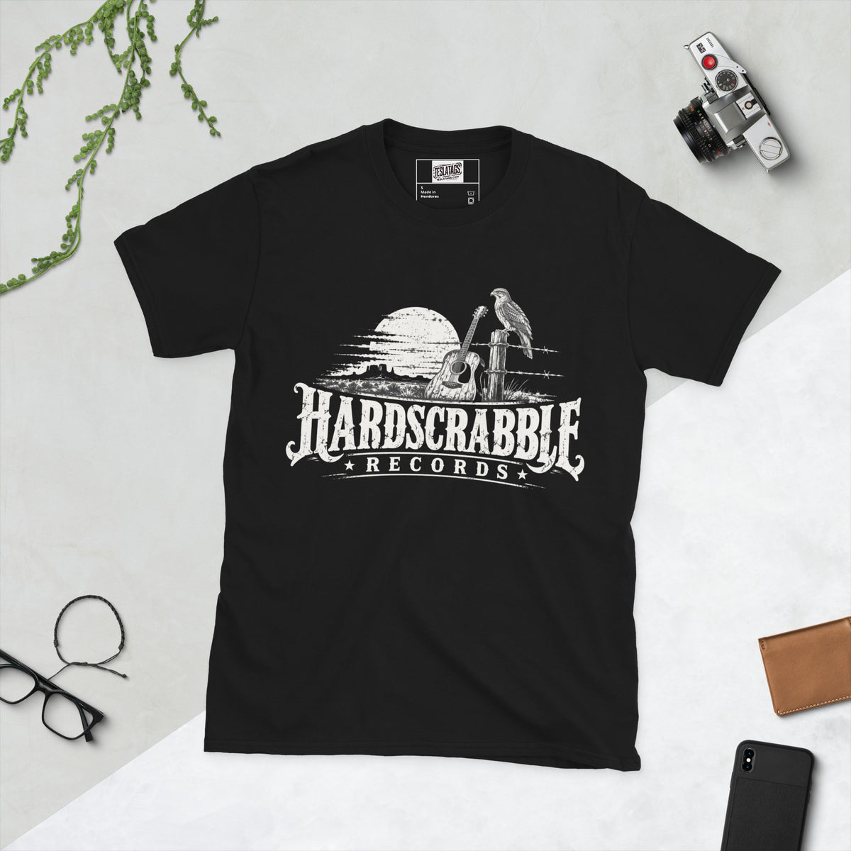 hardscrabble records t-shirt, black graphic tee, desert guitar illustration, hawk on fence post design, western record label graphic, vintage band merch print, rustic desert landscape art, southern rock streetwear shirt, acoustic guitar western design, unisex crew neck shirt